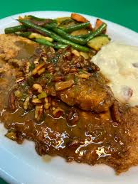 Brigtsen's Restaurant signature dishes Roast Duck à l'Orange with dirty riceBroiled Gulf Fish with Crab Crust & Lemon Crab SaucePan-Roasted Pork Chop with braised Napa cabbage and apple cider pan gravyPan-fried Gulf Fish Meuniere with Roasted Pecans